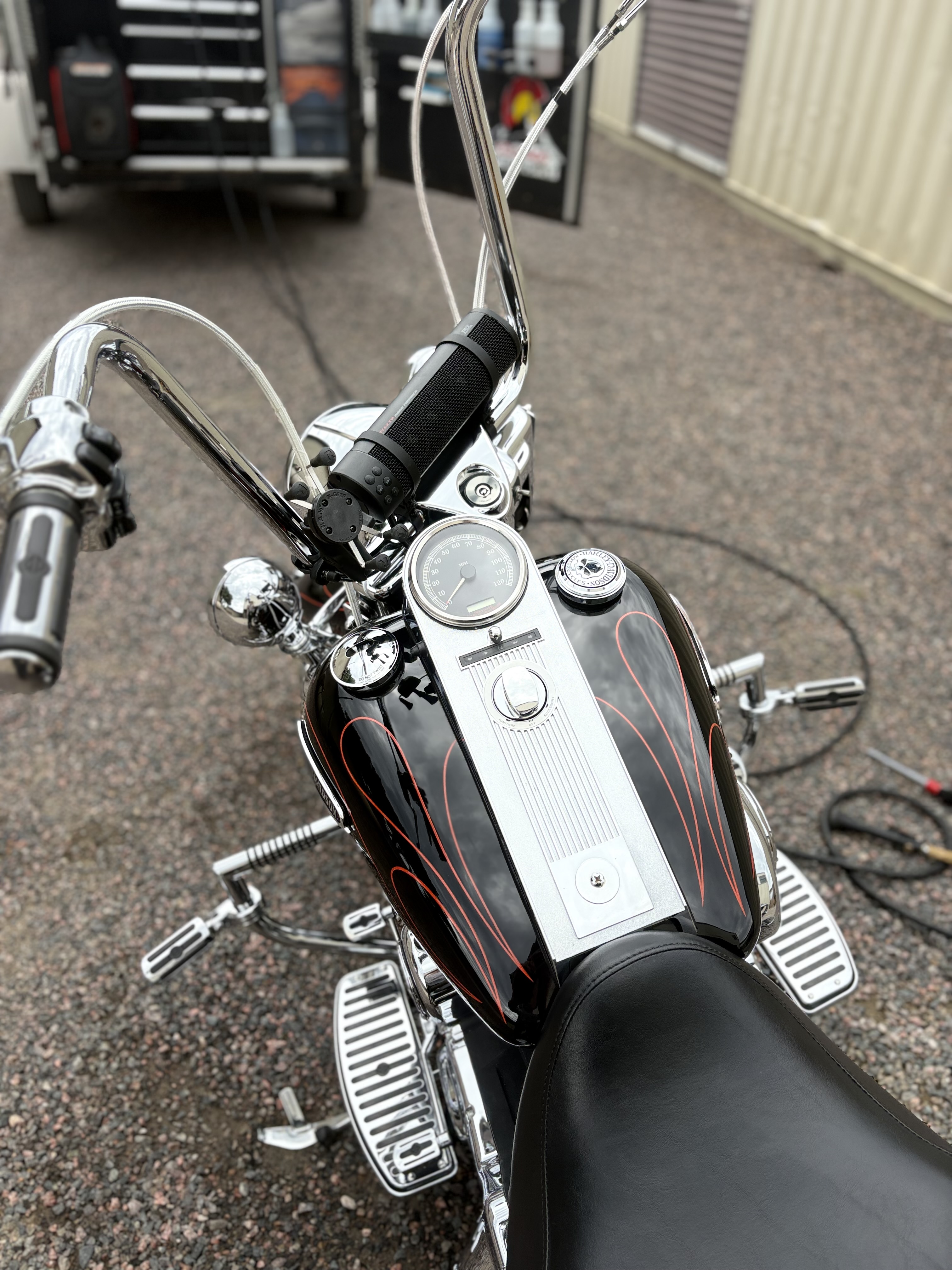Harley-Davidson fuel tank with orange pinstriping and polished chrome
